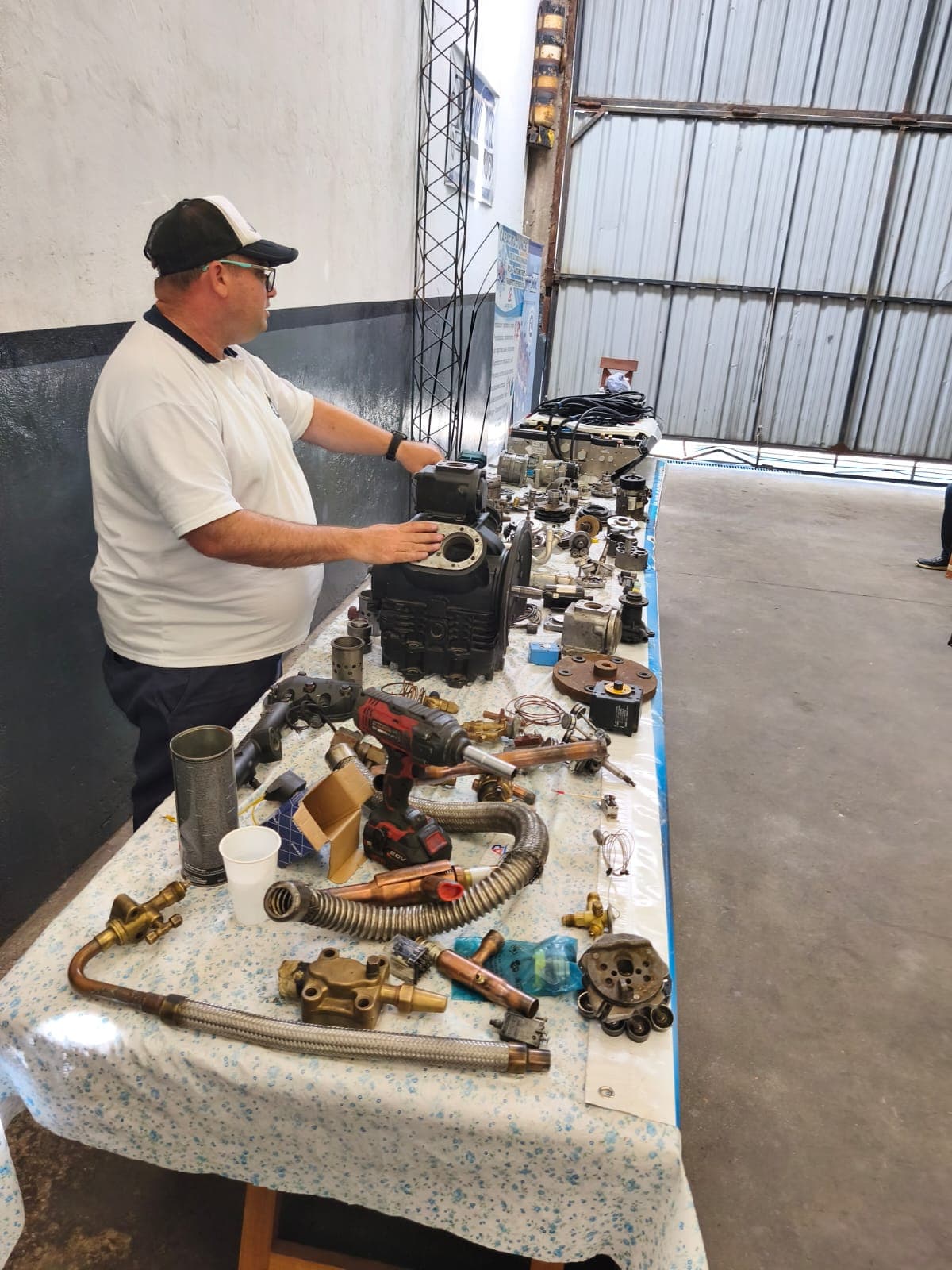 Hombre mesa trabajo — taller de Los Calvos Compresores, reparación de compresores de aire acondicionado automotor