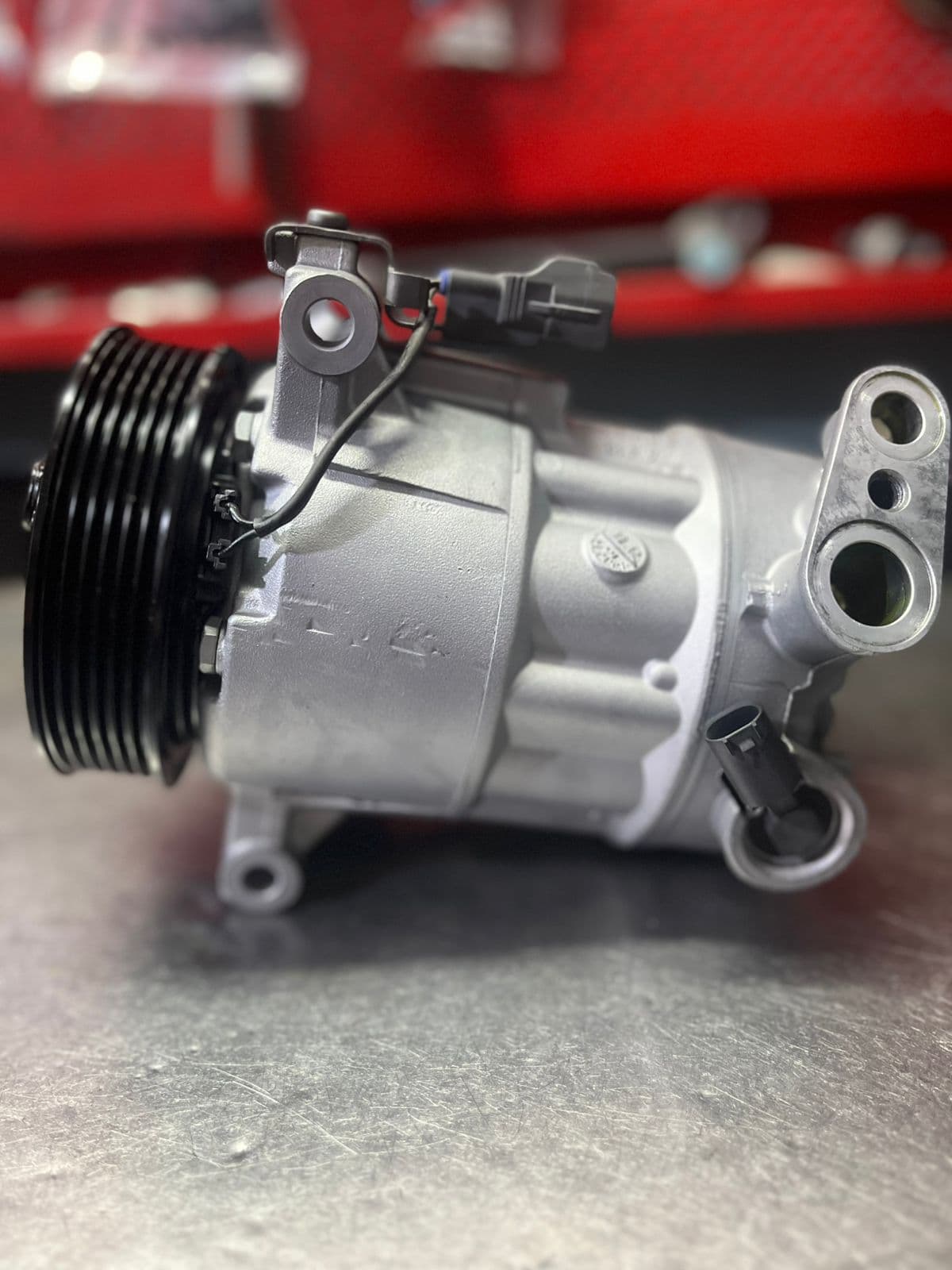 Compresor plateado — taller de Los Calvos Compresores, reparación de compresores de aire acondicionado automotor